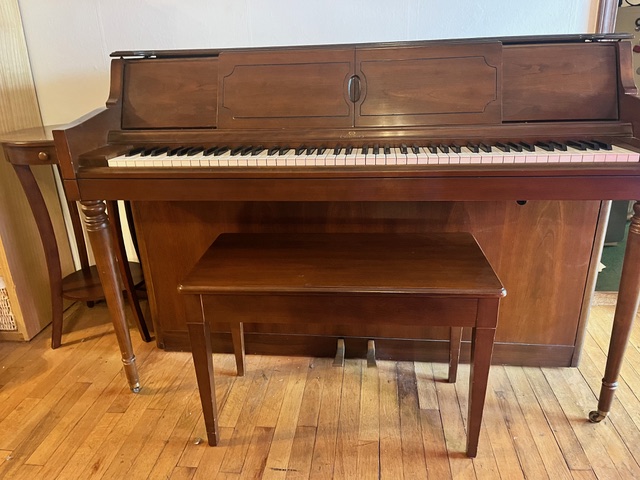 A piano with a bench
AI-generated content may be incorrect.